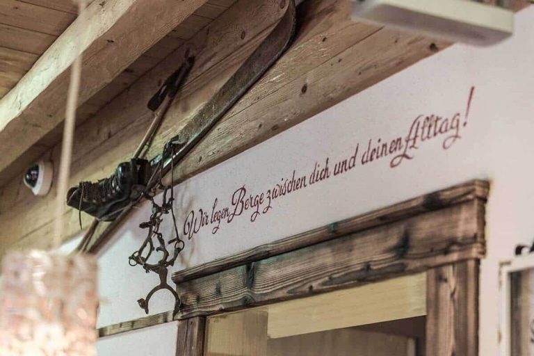Wandtext im Hotel Kaprun mit dem Spruch „Wir legen Berge zwischen dich und deinen Alltag!“