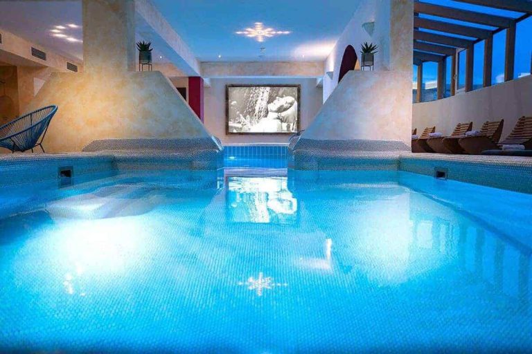 Kristallklares Wasser im Spa-Bereich des Vötter's Hotels mit entspannenden Liegen.