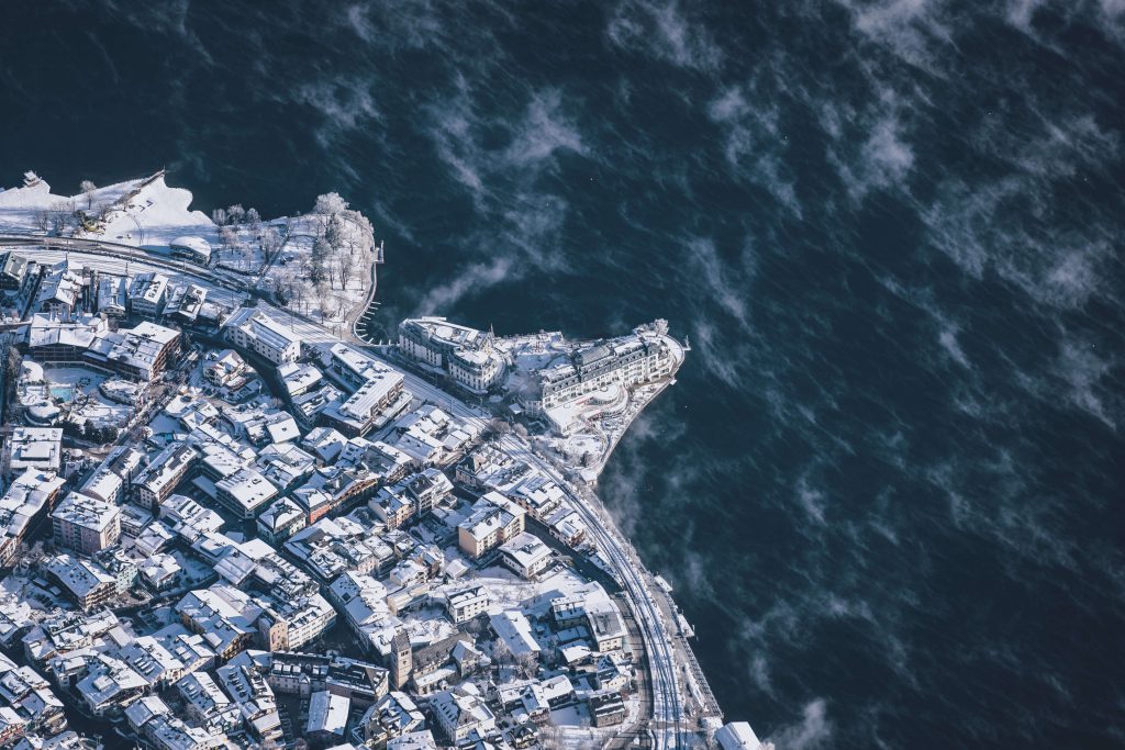 Vötters Hotel Kaprun Surrounded by Snow-Capped Mountains and the Glittering Waters of the Lake.