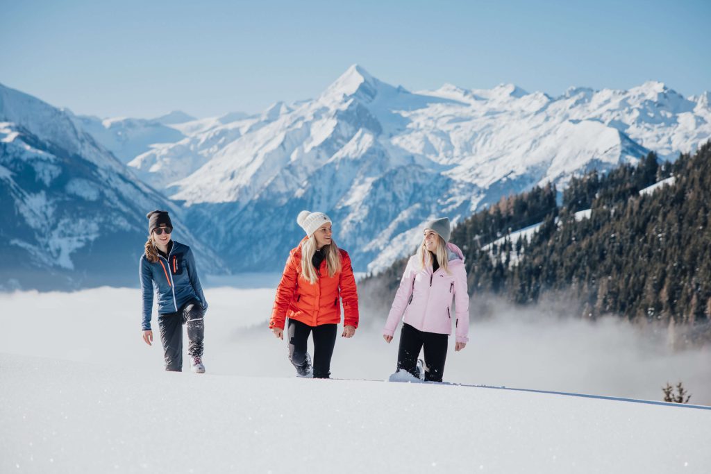 Three Women are Hiking in the Snow, Surrounded by Impressive Mountains in Kaprun.
